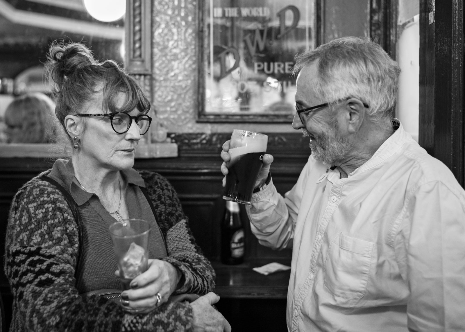 Ein älteres Paar sitzt beim Eingang. Während sie ihr Glas bereits leergetrunken hat und langsam nach Hause gehen möchte, hat er andere Pläne und genehmigt sich noch einen weiteren Pint Guinness. 03.11.2023, Dublin, Irland, © 2023 Raphael Diethelm