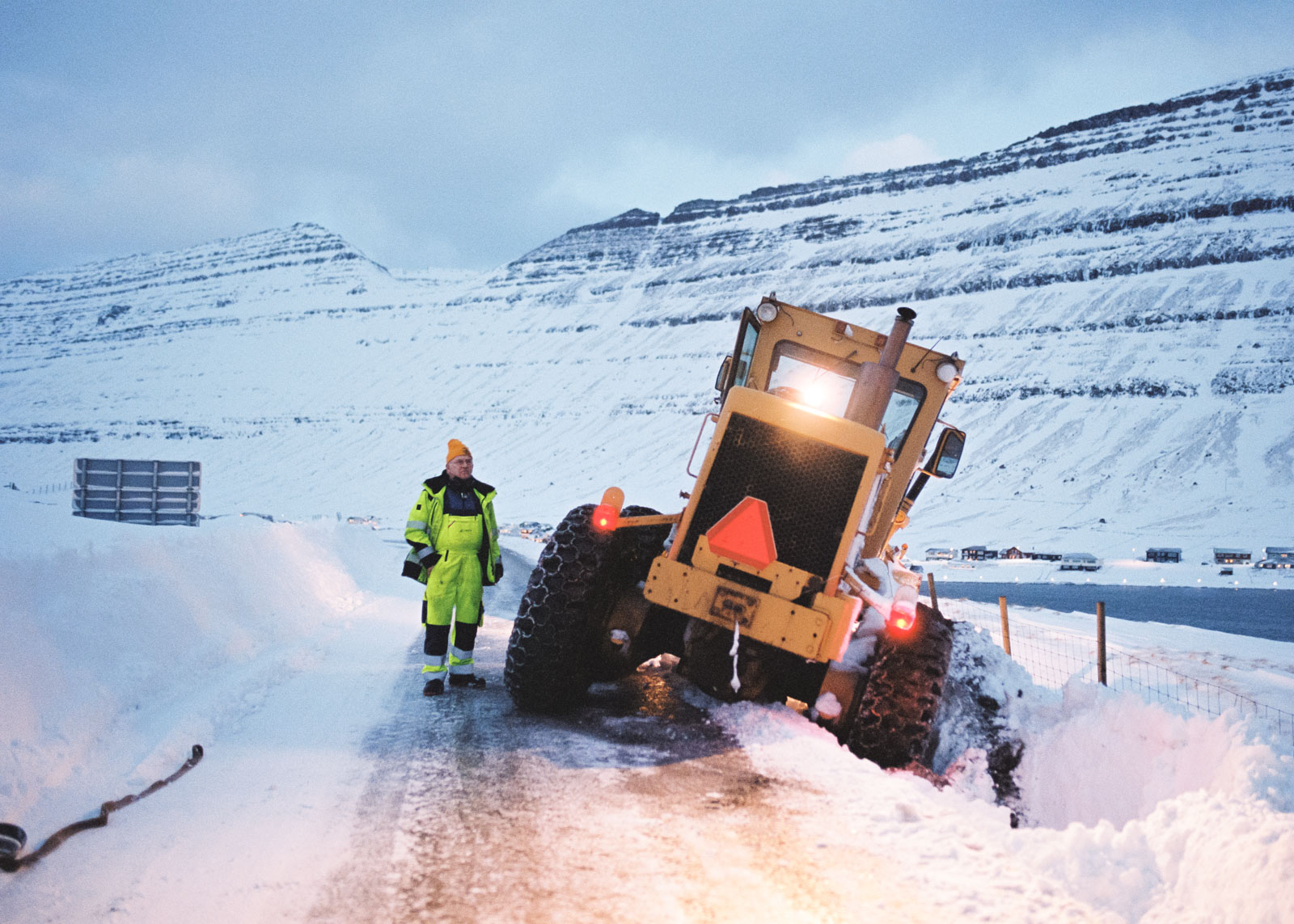 A worker is stuck in a roadside ditch with his snowplow due to heavy snowfall during an unusually lengthy cold period.Recurring extreme weather events pose new challenges even for the experienced Faroese. 20.12.2022, Húsavík, Faroe Island, ©2022 Niclas Tiedemann