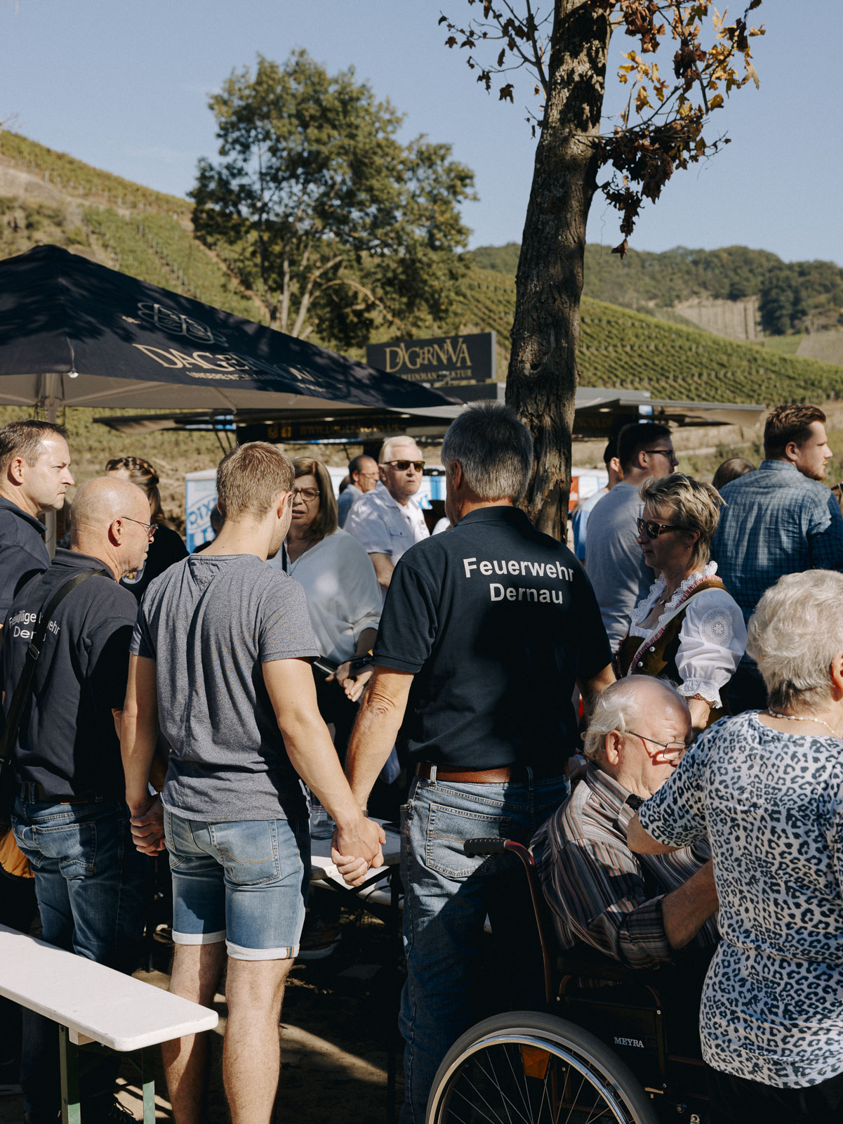 Menschen aus Dernau und Helfende stehen für eine Schweigeminute auf und halten sich an den Händen. 25.09.2021, Dernau, Deutschland, © 2021 Thomas Pirot