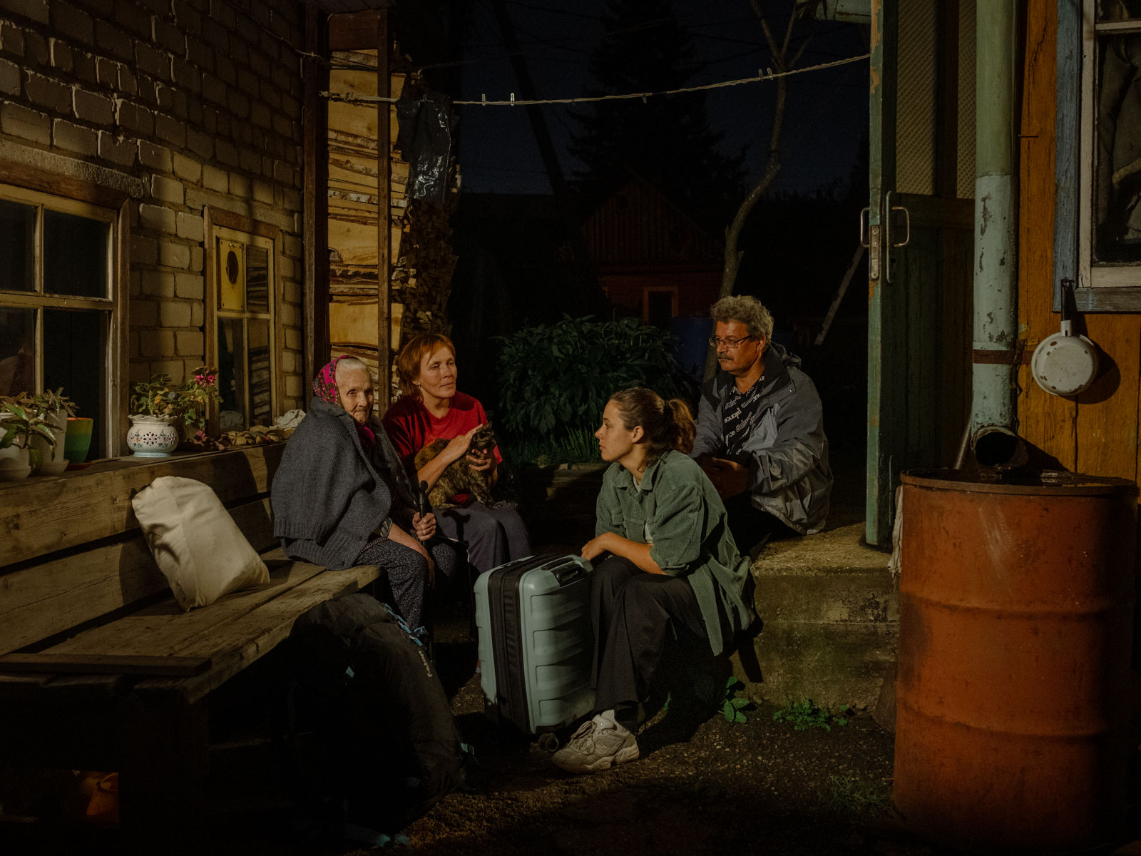 Selbstporträt von mir, meinen Eltern und meiner Oma, die auf der Veranda des Hauses sitzen, bevor ich nach Deutschland zurückkehre. Ich liebe diese russische Tradition des «Unterwegs-Sitzens». Man setzt sich für eine Minute zusammen und denkt über das nach, was man zurücklässt, Tomsk, 02.09.23, © 2023 Aliona Kardash