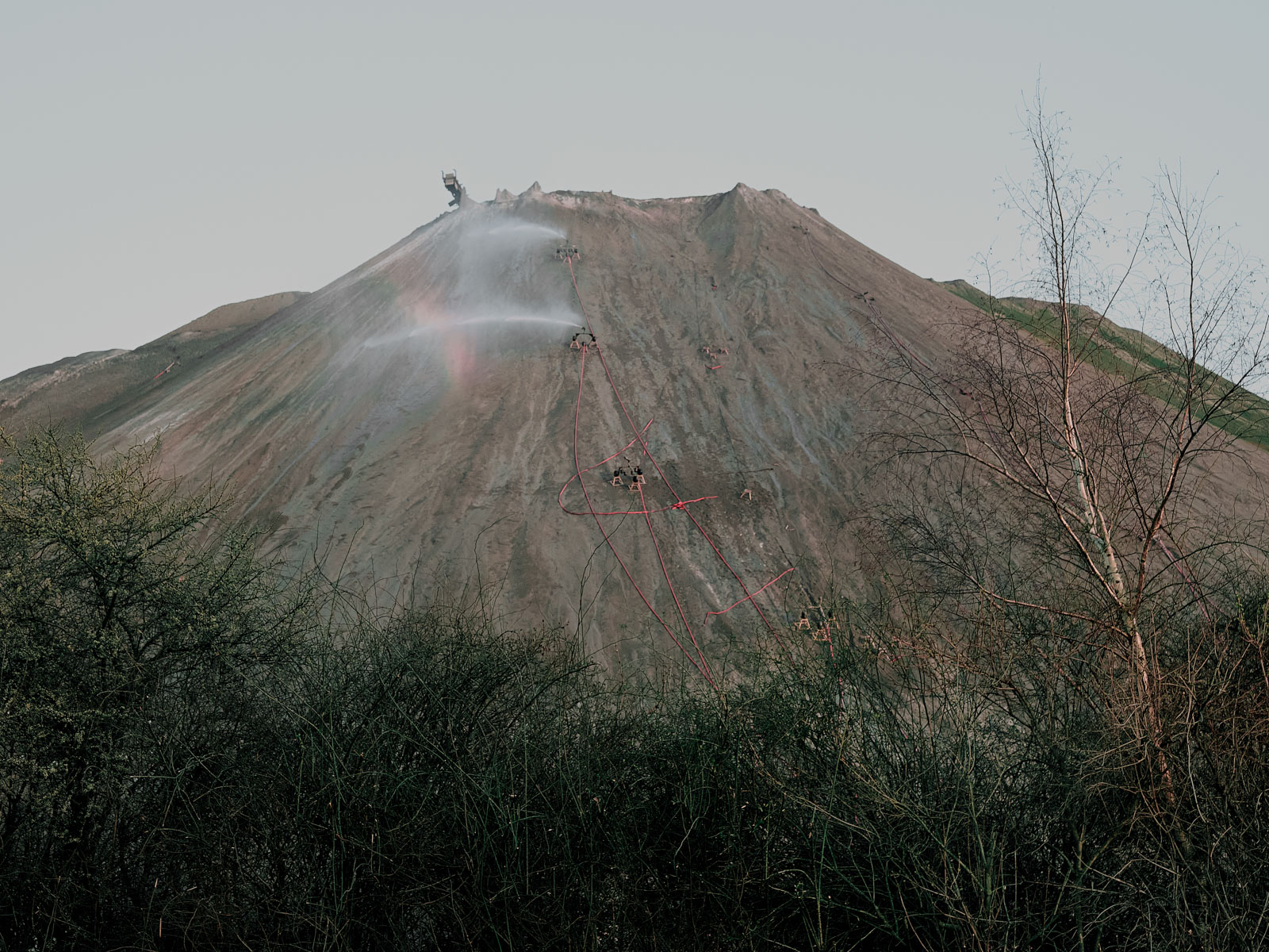 Die Kalihalde des stillgelegten Kaliwerks in Wunstorf bei Hannover wird künstlich bewässert. Um die Versickerung und Versalzung von Regenwasser zu minimieren werden immer mehr Kalihaden begrünt. Bürgerinitiativen in den umliegenden Dörfern kritisieren diese Maßnahmen, sie fordern oft eine vollständige Entfernung der Halden. 9.03.2024, Wunstorf, Deutschland, © 2024 Jasper Hill