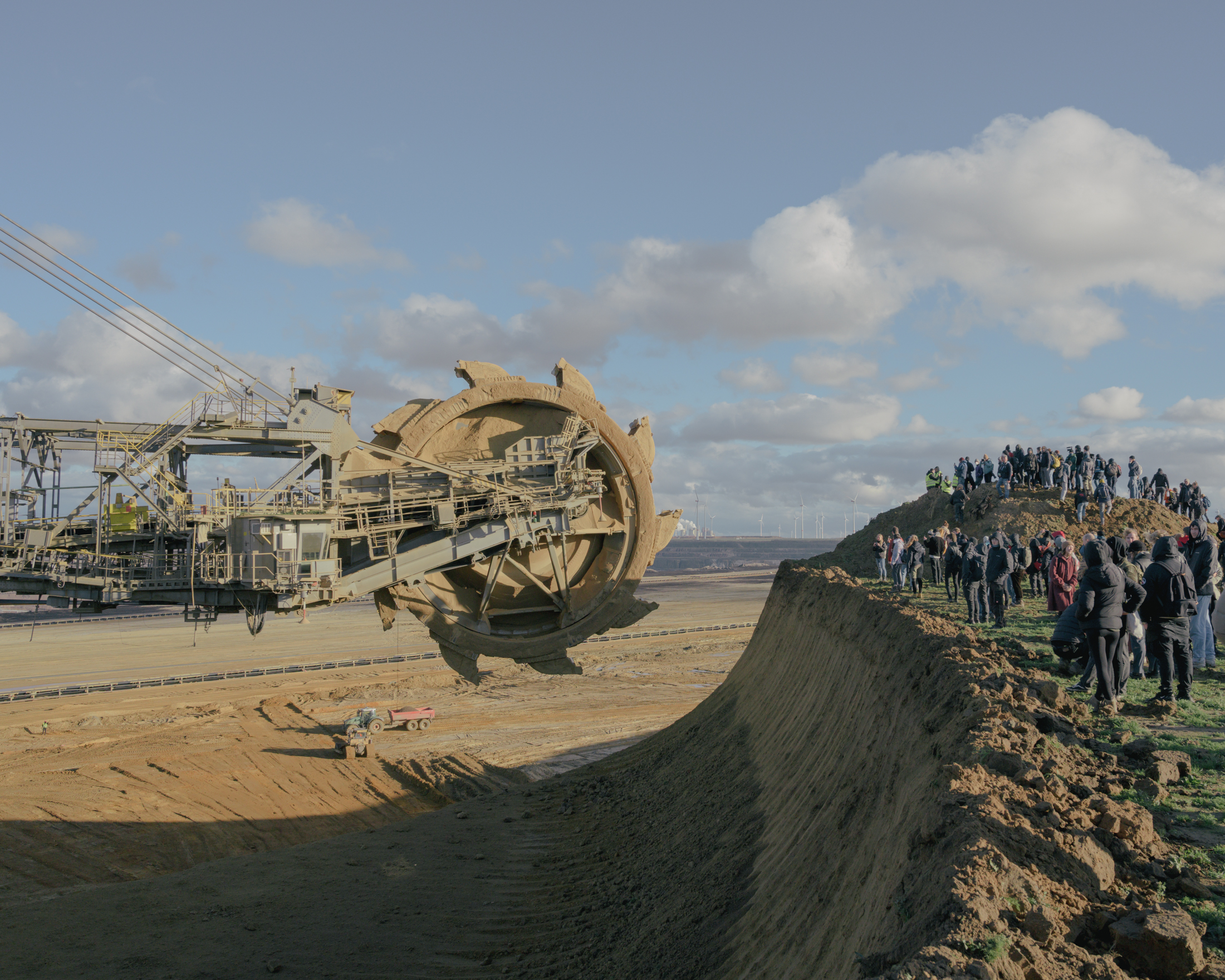 People are blocking the bucket-wheel excavator on the edge of the Garzweiler II open-pit mine near the outskirts of Lützerath, Germany, on January 8, 2023. When individuals are present in the danger zone at the edge of the mine, the bucket-wheel excavator must pause its operation until the affected area is vacated by those individuals, © 2023 Ingmar Björn Nolting 