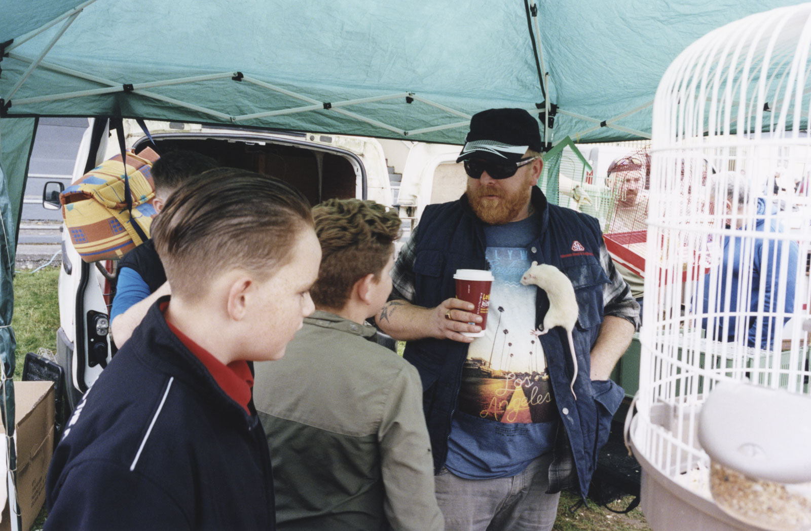 The photo shows Kids on the fair with a men and his rat on the shirt. 19.10.2023 Ballinasloe, Ireland © 2023, Frederik Rüegger