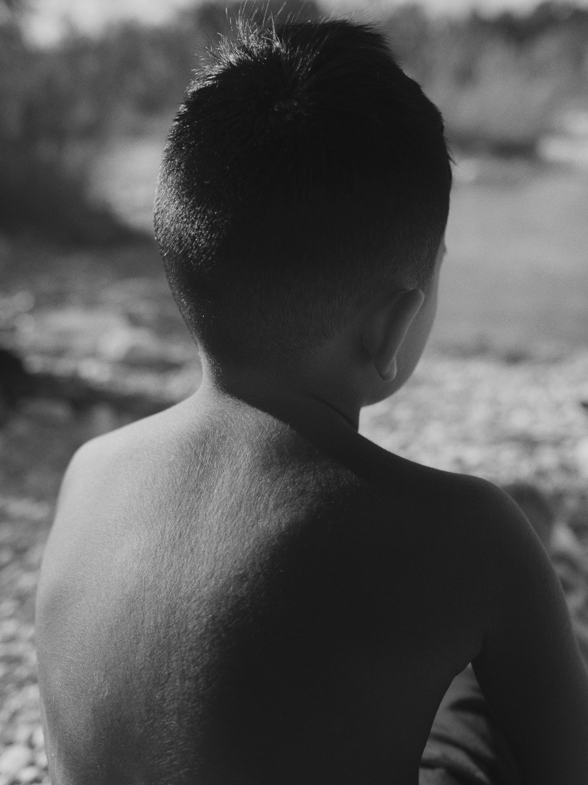 Alejandro am Fluss Nueces. Er und sein Vater gehen regelmässig hier schwimmen. Sie haben eine spirituelle Verbindung zur Natur. Sein Vater beschreibt sich selbst als Chicano, halb Mexikaner, halb Amerikaner. Das Wort Chicano wurde oft verwendet, um die Identität der hispanischen Bevölkerung zu diffamieren. 07.10.2024, San Patricio, Texas, USA, © 2026 Alexander Nowak