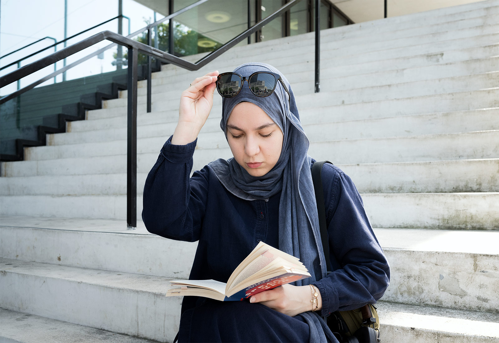 Feyza Hilal Karabulut erzählt, dass sich das Tragen von Bescheidenheit zu Hause grundlegend anders anfühlt als im öffentlichen Raum. In den eigenen vier Wänden tritt ihr religiöser Ausdruck in den Hintergrund; draussen kann religiöse Sichtbarkeit zur Frage von Sicherheit werden. Diese Szene stellt sie für mich nach. 13.08.2025, Basel-Stadt, Schweiz, © 2025 Azura Silberschmidt